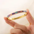 Nahaufnahme der lebendigen Emaille-Einlage auf diesem eleganten goldenen Edelstahlarmreif - Bunte Wolken (sz820) / Gold