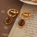 Vintage style gold-tone earrings featuring oval tiger eye stones and textured knot design - Metal Knot with Brown Gemstone Style (E3-21025A-6000)