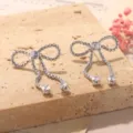 Dettaglio macro di orecchini a lobo a fiocco in argento con cristalli lucenti - Stile Orecchino a Lobo con Fiocco Strass Argento (2-27274A-5200)