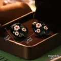 Gros plan de boucles d'oreilles ovales en émail noir avec motifs de fleurs blanches. - Peinture à l'Huile Noire Ovale (E4-21990-6000)