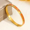 Eleganter Armreif aus goldfarbenem Edelstahl mit orangefarbenem Emaille und Blumenmuster. - Tulpenstil auf orangefarbenem Grund (6MMSZ714) / 6mm Breite