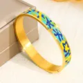Eleganter Armreif aus goldfarbenem Titanstahl mit buntem Emaille-Inlay und Symbolmuster - Abstrakter Symbolstil (SZ720) / 10mm Breite / Gold