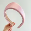 Primer plano de una diadema acolchada triangular rosa con textura satinada elegante - Rosa Claro