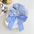 Close-up of blue and white striped fabric bow scrunchie on a decorative white plate. - Blue Bow Scrunchie / Blue