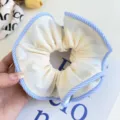 Close-up detail of a large Korean style cream scrunchie with blue striped edges - Striped Edge Scrunchie / Yellow