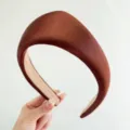 Detalle de cerca de una diadema de satén acolchada marrón con un diseño vintage. - Marrón
