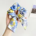 Close-up of an oil painting style blue and yellow gradient scrunchie with a pearl charm. - Bow with Pearl and Fu Charm Scrunchie