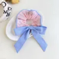 Detail view of a blue and white striped fabric bow scrunchie displayed on a white plate - Pink Bow Scrunchie / Pink