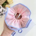 Macro detail of a pink fabric scrunchie with blue striped edges for hair styling - Striped Edge Scrunchie / Pink