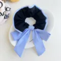 Macro view of blue striped fabric scrunchie with elegant bow detail for hair styling. - Black Bow Scrunchie / Black