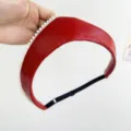 Primer plano de una diadema de cuero rojo con perlas y correa ajustable. - Diadema de perlas / Tamaño ajustable / Rojo