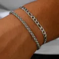 Nahaufnahme von Edelstahl Figaro- und Weizenketten-Armbändern an einem Männerhandgelenk - Figaro- und Weizenketten-Kombi (#1) / Zweiteiliges Set
