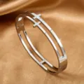 Silver-colored hollow stainless steel bangle with rhinestone-paved cross detail - Steel Color (sz018)