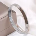 Detailed view of the classic vintage Greek key pattern engraved on a silver bangle - Meander Buckle Style (sz801) / Steel
