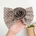 Nahaufnahme der 3D-Rose aus Karostoff und des Schleifendesigns der eleganten Haarspange - Blumen-Schleifen-Haarklammer / Schwarzkaffee-Karo