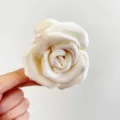 Gros plan sur une pince à cheveux rose en satin crème montrant les pétales délicats - Pince à Rose Double Face (S380) / Blanc Cassé