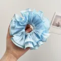 Detail eines hellblauen übergroßen gerafften Organza-Haargummis mit Stofflagenstruktur - Doppelt Gerüschter Scrunchie / Blau