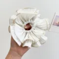 Detailaufnahme eines übergroßen weißen Falten-Scrunchies mit eleganter Textur und Größe - Doppelt Gerüschter Scrunchie / Weiß