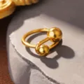 Makroaufnahme eines gold polierten Titanstahl-Ringes mit zwei Kugelenden. - Doppelball Oval Wickelstil (STR-0075-1800) / Gold