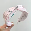 Close-up of pink floral twisted wide headband with delicate flower pattern - Twist Knot Style (S180) / Pink National Wind Print