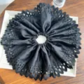 Vue détaillée du chouchou géant en tissu plissé noir avec des motifs découpés au laser précis. - Noir