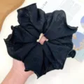 Detalle de un coletero grande negro con capas de pliegues y bordes de volantes texturizados. - Coletero Grande Plisado / Negro