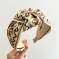 Detailansicht eines breiten Knotenstirnbands mit retro-ethnischem geometrischem Muster - Beige Gelb Kaffee Ethno Geknotetes Haarband