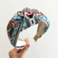 Nahaufnahme eines ethnisch bestickten geknoteten Stirnbands mit geometrischen Mustern - Blau Grün Ethno Geknotetes Haarband