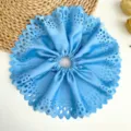 Vue détaillée d'un grand chouchou plissé bleu avec des motifs élégants découpés au laser - Bleu