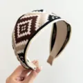 Detailansicht eines ethnischen Stoffstirnbandes mit braunen geometrischen Mustern. - Beige Kaffee Ethno Breites Haarband
