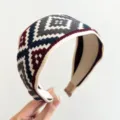 Nahaufnahme des ethnischen geometrischen Strickmusters auf dem breiten Stoffstirnband - Rot Blau Ethno Breites Haarband