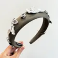 Détail rapproché des pétales métalliques argentés sur un serre-tête en tissu olive. - Pétale en Métal Étoile / Vert foncé