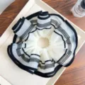 Detailansicht eines großen Netz-Scrunchies mit eleganten schwarzen Streifen - Cremeweiß mit schwarzer Paspel (Gequiltet)