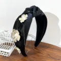 Detail view of golden metal flowers and pearls on a black satin knotted headband - Knotted Flower Headband / Black