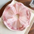 Makroaufnahme des rosa gefalteten Mesh-Haargummis mit eleganten Satinbandkanten - Rosa (Gequiltet)