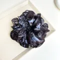Detail view of tie-dye fabric scrunchie with ruffled layers and black piped edges - Scrunchie (S262) / Blue Tie-dye