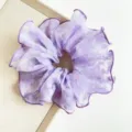Close-up detail of a purple floral lace scrunchie featuring delicate ruffled edges for hair - Large Printed Style / Purple