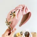 Detail view of pink satin knotted headband with metallic 3D flower and crystals - 3D Rhinestone Flower Knotted Headband / Pink