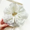 Close-up of white double-layered lace floral scrunchie hair tie for bun hairstyles - Large Printed Style / Off White