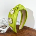 Detailed view of lime green satin knotted headband decorated with metallic pearl flowers. - Knotted Flower Headband / Green