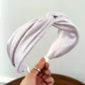 Detailopname van de lavendelkleurige glinsterende stof op een brede geknoopte haarband - Glinsterende Kruisstijl / Roze