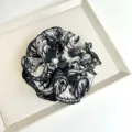 Close-up detail of a ruffled hair scrunchie with black and white tie-dye pattern - Black and White Tie-Dye Scrunchie