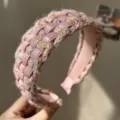 Detailopname van een roze gevlochten haarband van wol en leer met textuur - Roze