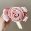 Detailed close-up view of a pink velvet rose hair clip with elegant satin ribbon bows - Pink