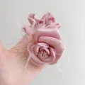 Close-up of elegant pink satin camellia hair scrunchie with ostrich feathers - Rose Ostrich Feather Hair Tie / Sakura Pink