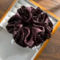 Macro view of brown velvet scrunchie with elegant pearl charms in a tray - Pleated Hair Tie with 5 Artificial Pearls / Coffee