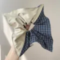 Detailed close-up view of an oversized fashion hair scrunchie in beige and blue plaid fabric - Beige Patchwork Scarf Scrunchie / Navy Plaid