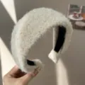 Gros plan détaillé d'un serre-tête en laine beige pelucheuse au design bombé - Serre-tête Large / Beige