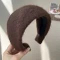 Gros plan d'un serre-tête marron duveteux montrant sa texture épaisse et son design large. - Serre-tête Large / Peluche Café