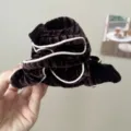 Macro detail view of a dark brown velvet sponge headband with contrasting pink piping - Pleated Edged Claw Clip